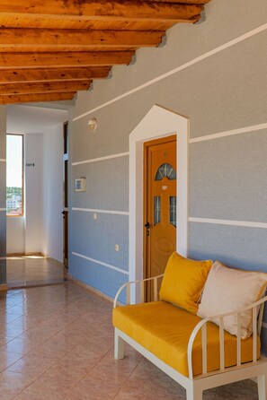 A hallway with a wooden ceiling, a door marked 501, and a yellow and white bench.