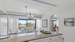 A kitchen with a granite countertop, white cabinetry, and a view of the outdoors. - Gorgeous 3 bedroom 2 bath unit. Beachfront property! (Destin)