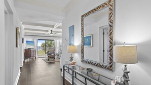 A hallway with a glass console table, decorative lamps, and a large ornate mirror. - Gorgeous 3 bedroom 2 bath unit. Beachfront property! (Destin)