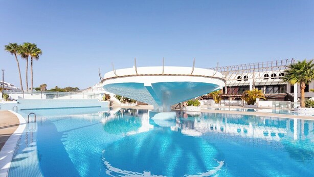 A large swimming pool with a unique architectural feature resembling a boat's hull. - Home2Book Sun & Pools Costa del Silencio (Costa del Silencio)