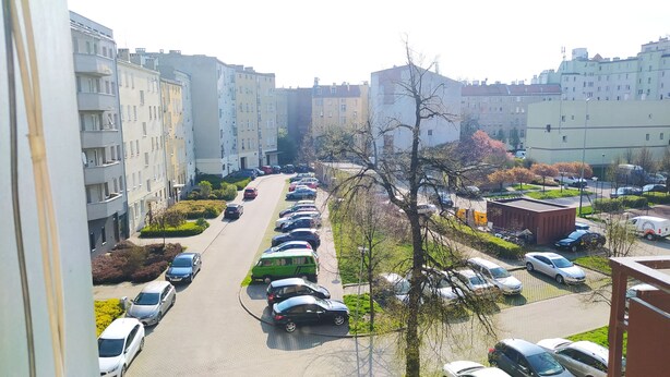 Eine Wohnstraße mit parkenden Autos und Mehrfamilienhäusern.