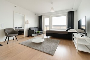 En moderne stue med sofa, lænestol, sofabord og TV-møbel.