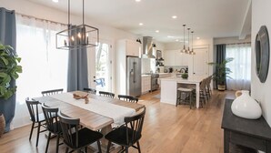 A modern kitchen with white cabinets, a central island, and pendant lighting.