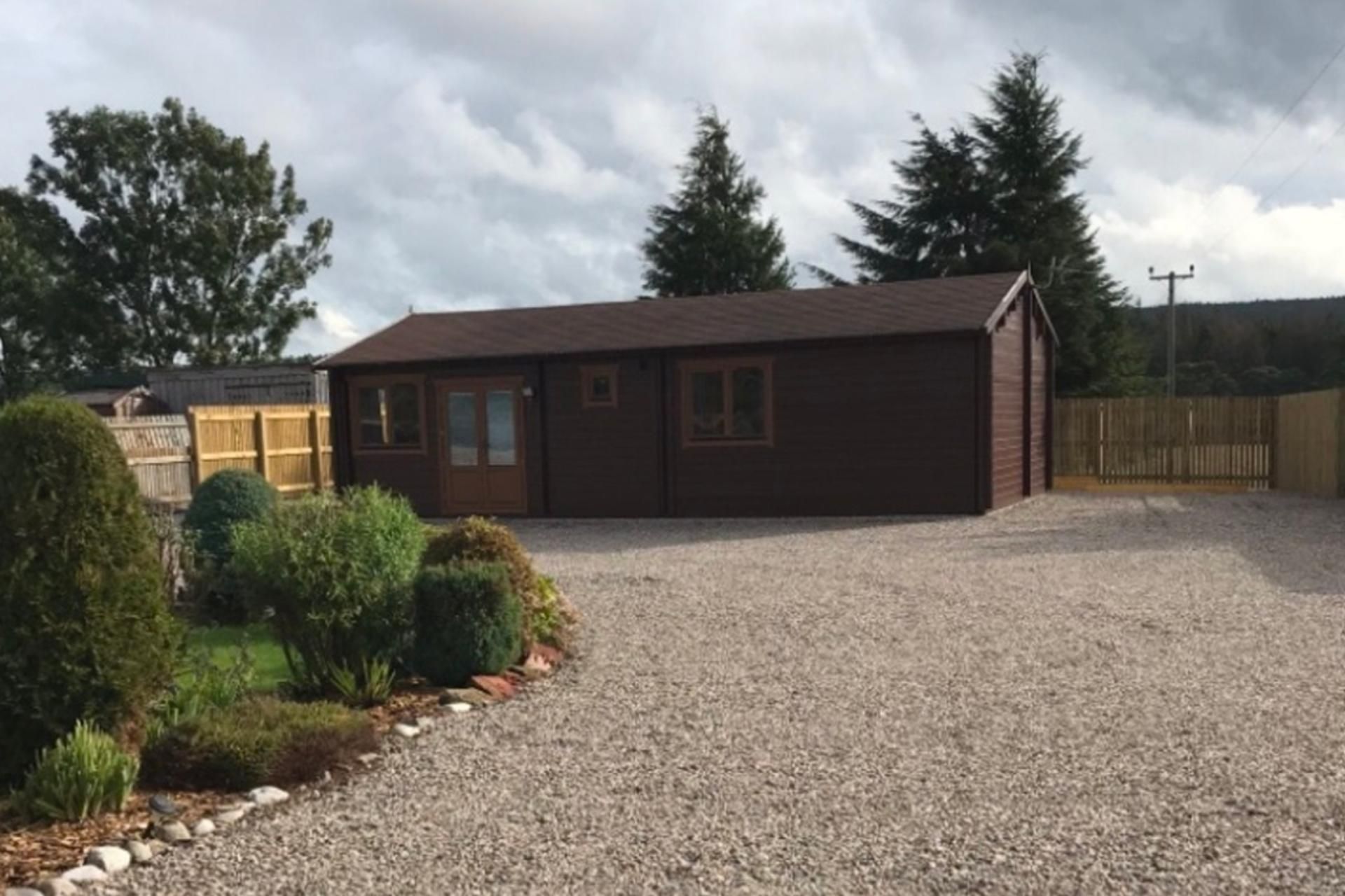 A single-story building with a gravel driveway and a fenced yard.