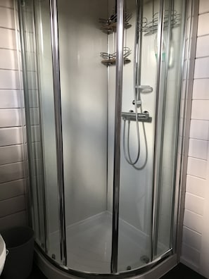A glass-enclosed shower stall with a handheld showerhead and a wall-mounted faucet. - Lovely 1-bed House in Fochabers, Scotland (Fochabers)