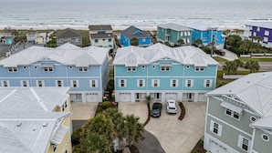 A coastal residential area with houses featuring gabled roofs and a view of the ocean.