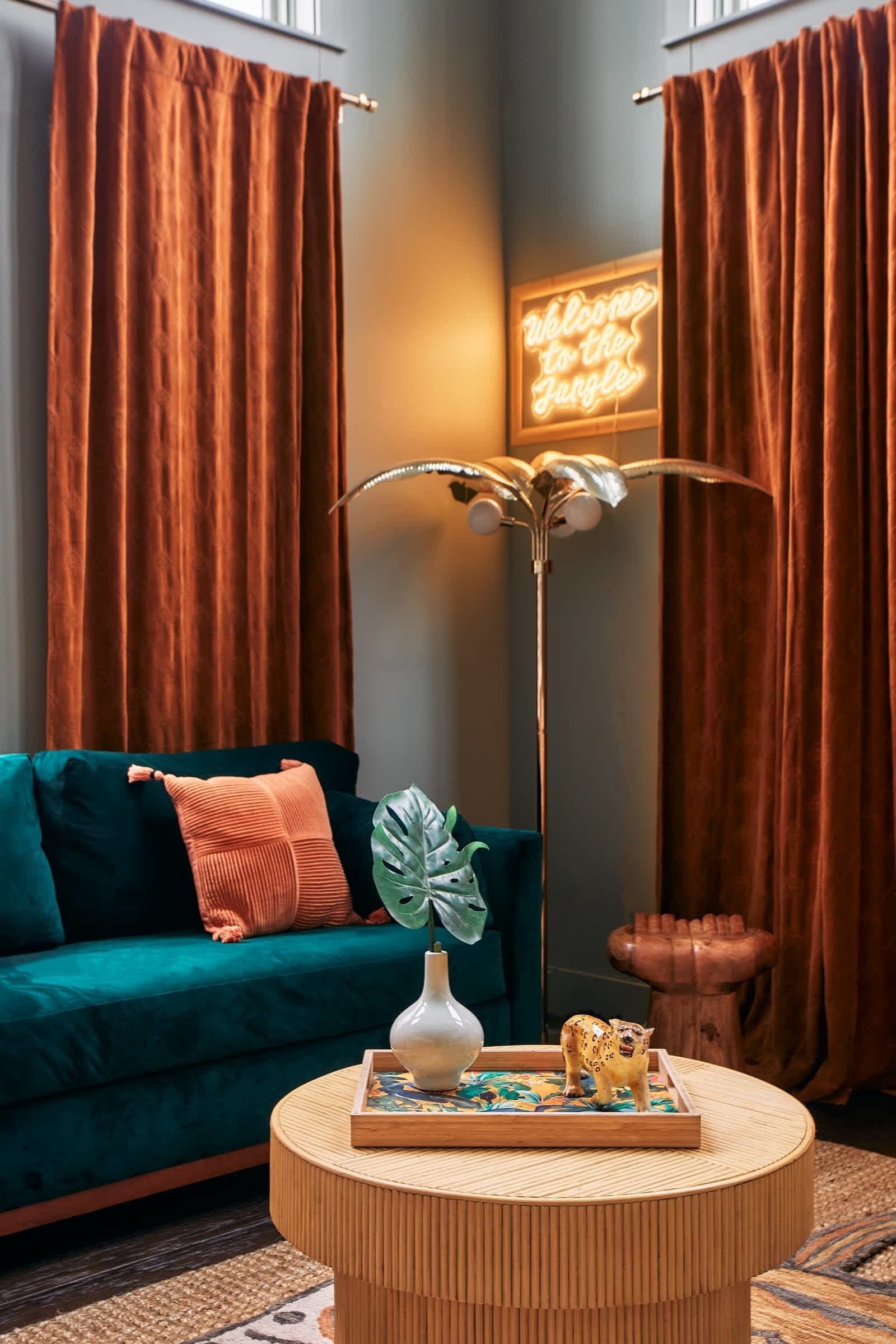Un salon chaleureux avec un canapé de couleur turquoise, une table basse ronde en bois et une plante décorative.