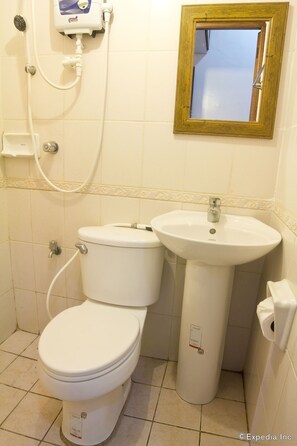 A bathroom with a toilet, sink, and shower.