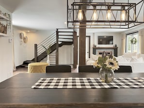 Relax in this inviting living space with a dining area, comfortable sofa, and cozy fireplace.