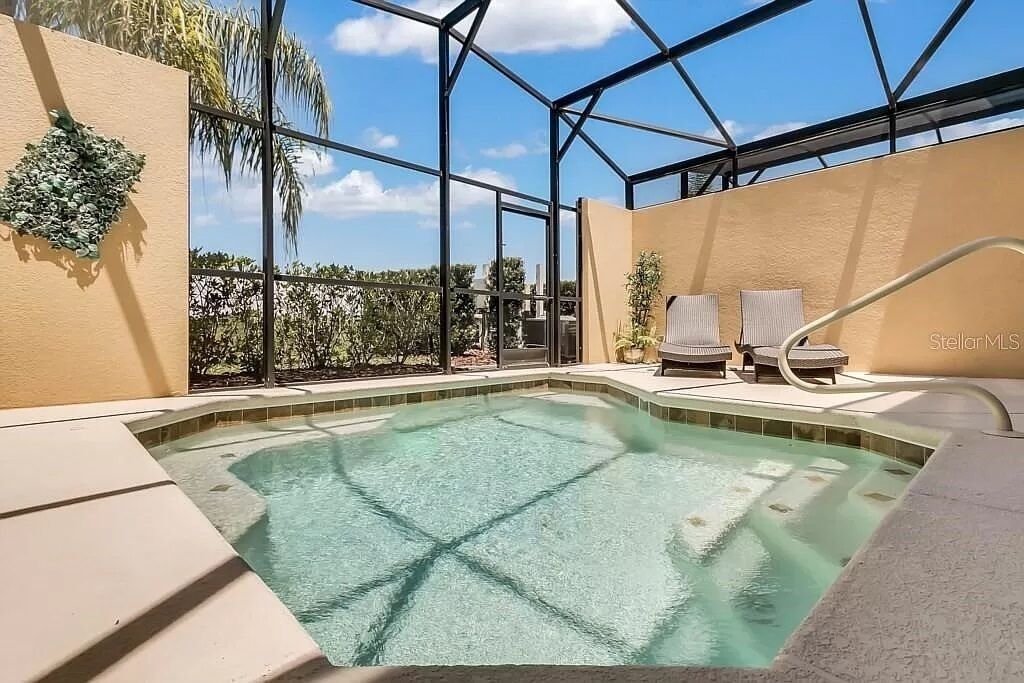 Una piscina interior con agua cristalina, rodeada de paredes color beige y un techo de vidrio.
