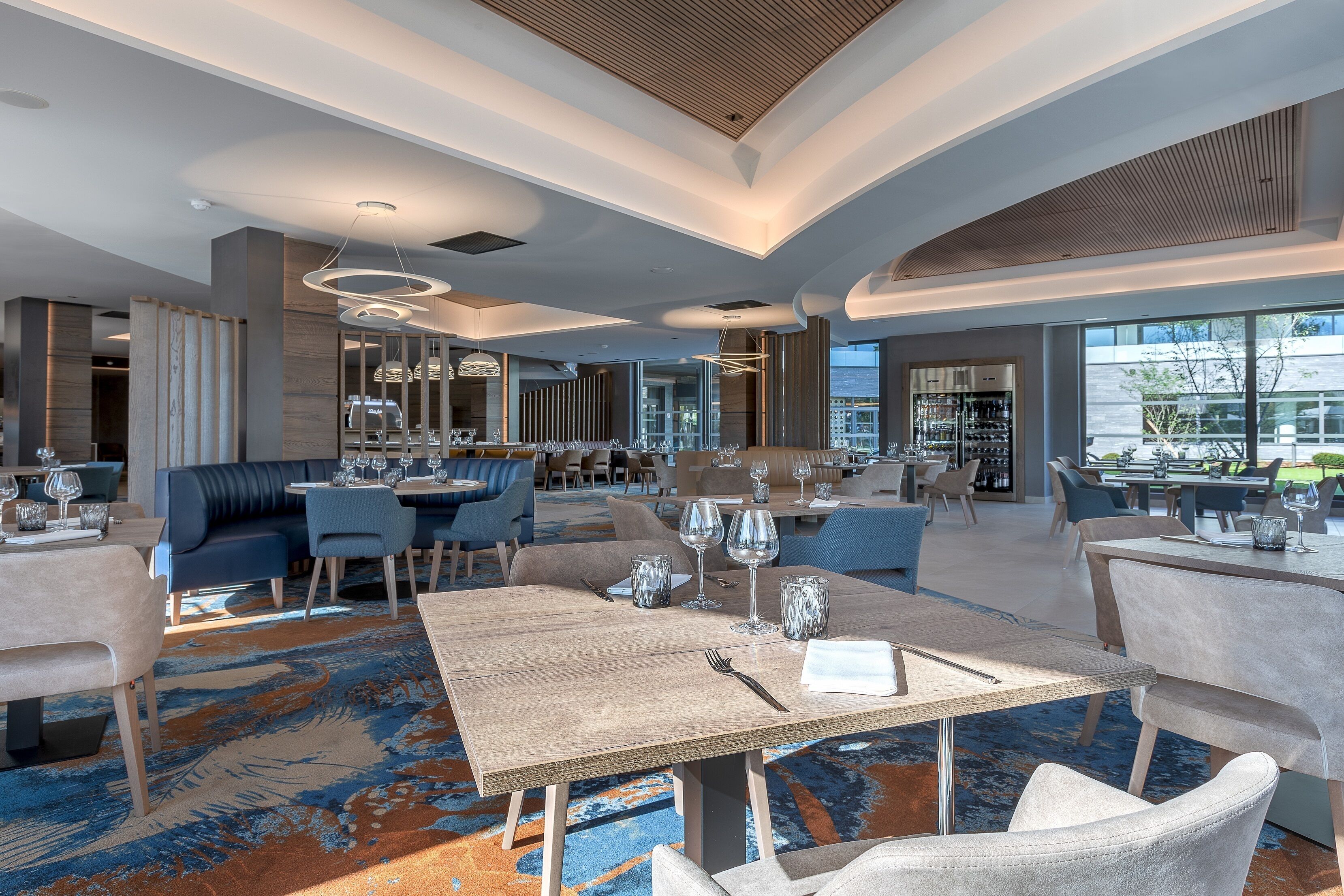 Un comedor espacioso con muebles modernos y un amplio ventanal con vistas al exterior.