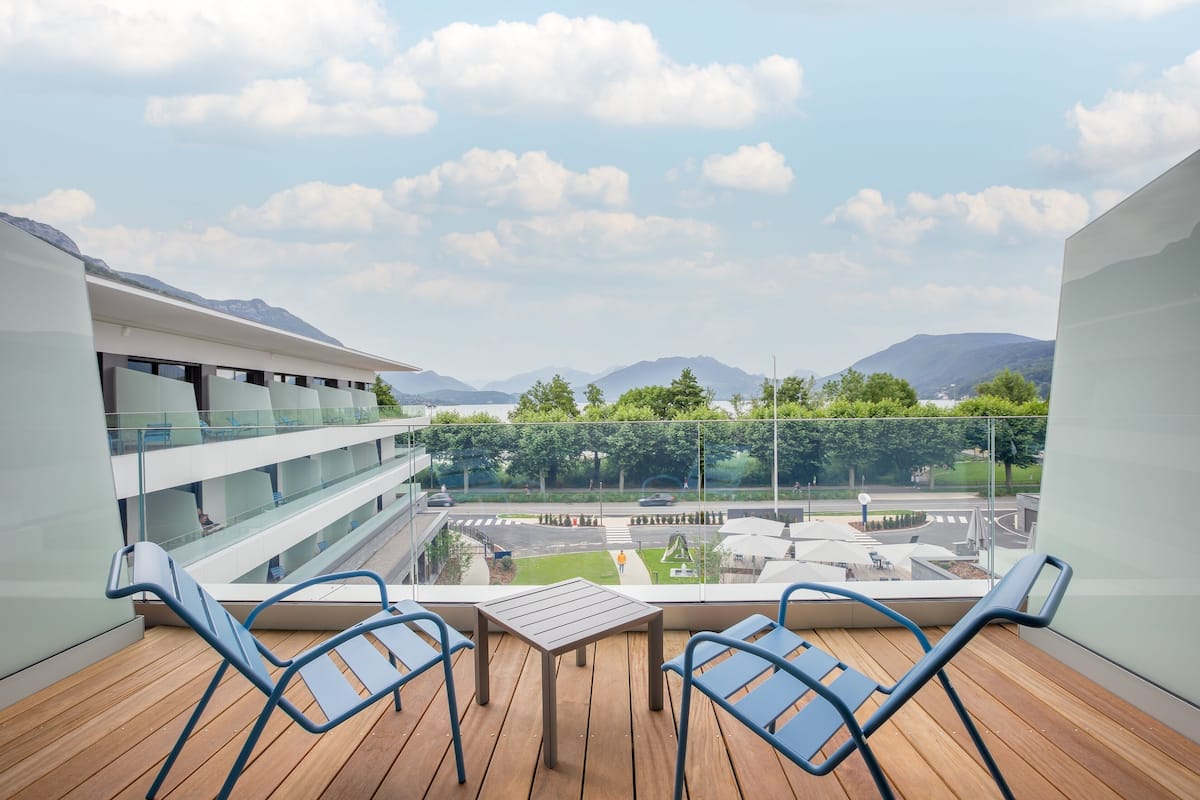A balcony with a view of a cityscape, including mountains and a road.