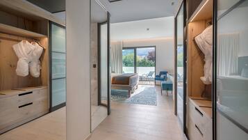 Quarto de hotel moderno com guarda-roupa de madeira, cama com vista e área de estar também com vista.