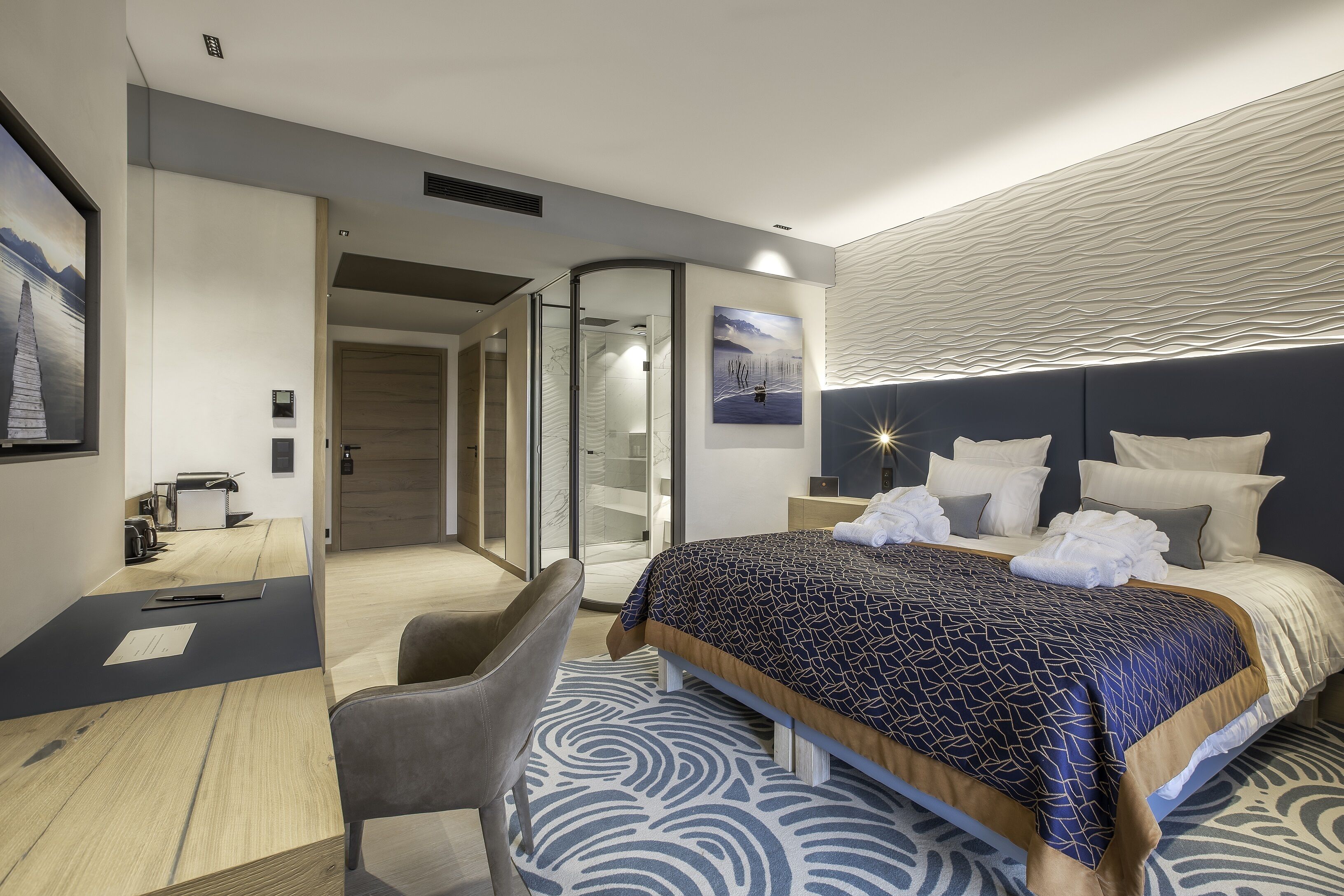 Una moderna camera d'albergo con un letto, una scrivania e una sedia.