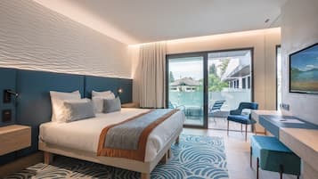 A modern hotel room with a large bed, a desk, and a view of the outdoors.