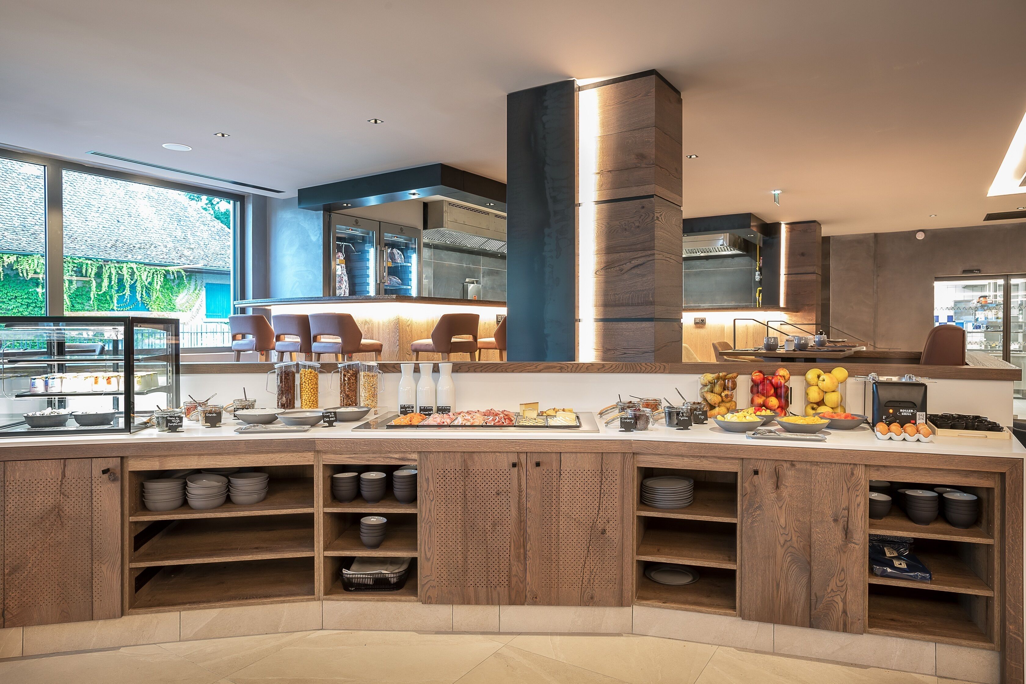 Un bar à petit-déjeuner moderne proposant une variété de plats et une vue sur l’extérieur.