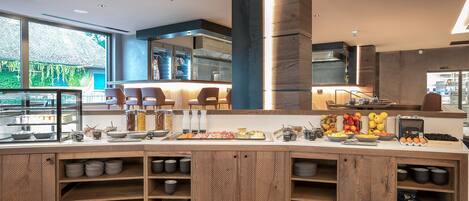 Un bar à petit-déjeuner moderne proposant une variété de plats et une vue sur l’extérieur.