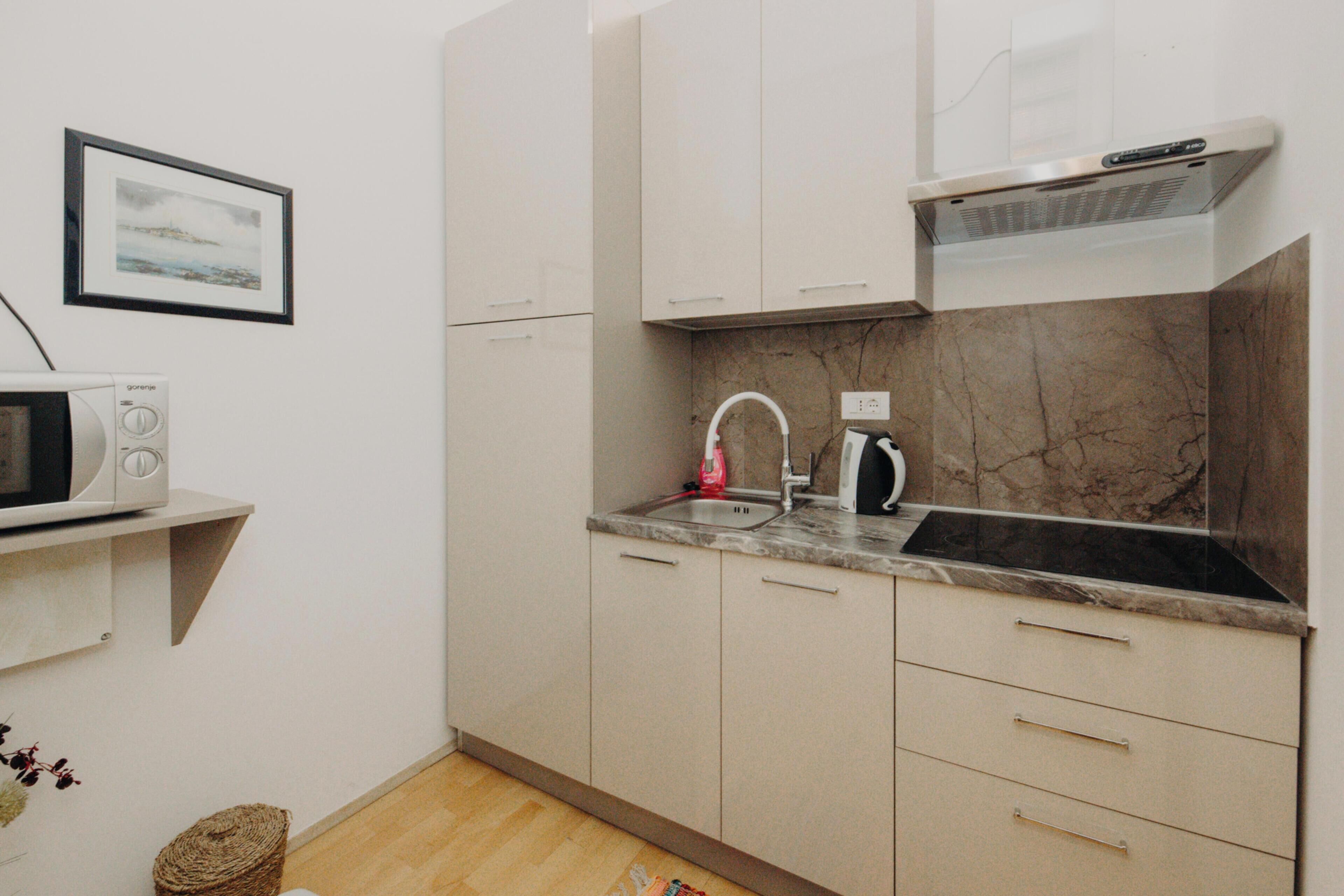 A compact kitchen with a microwave, sink, and stove.