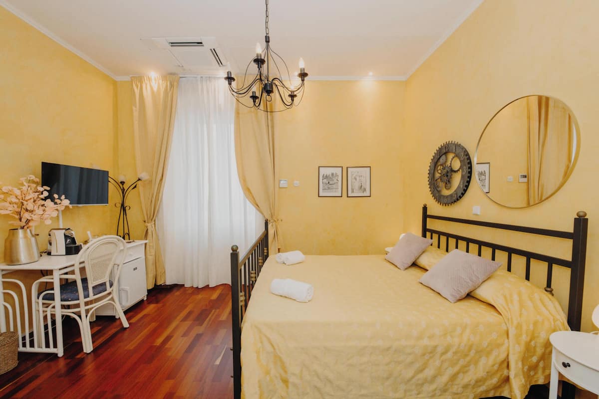 Une chambre à coucher comprenant un lit, une table de chevet et un bureau avec une chaise.