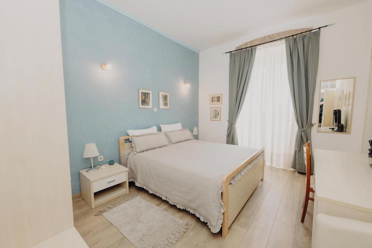 Une chambre à coucher avec un lit, une table de chevet, une lampe et un miroir.
