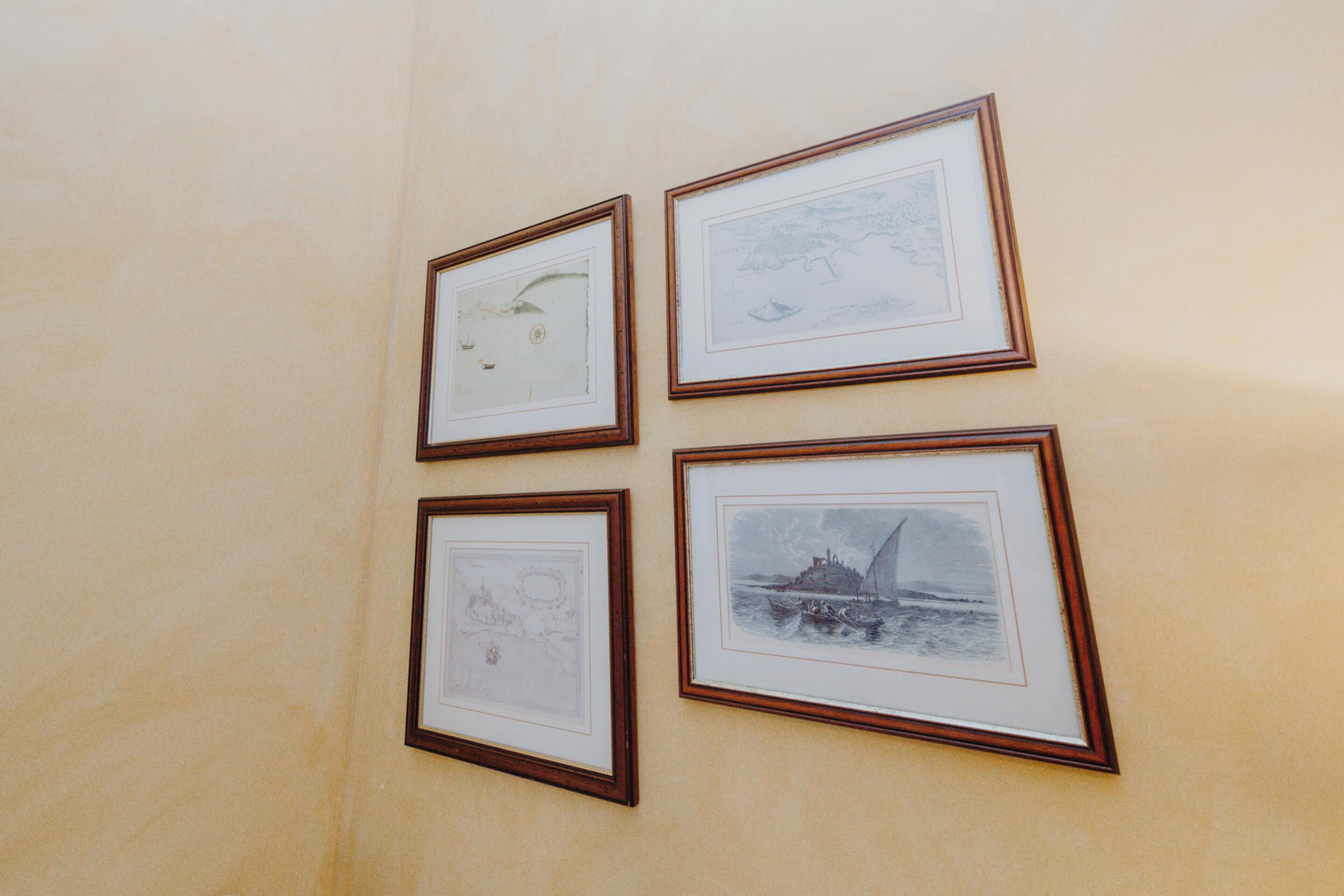 Vier gerahmte Kunstwerke an einer Wand.