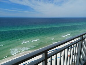 A balcony with a view of the ocean and beach.