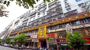 A multi-story building with various shops on the ground floor. - Jiu Tian Fashion Hotel (Fuzhou)