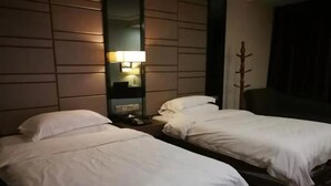 A hotel room with two single beds, a nightstand with a lamp, and a coat rack. - Jiu Tian Fashion Hotel (Fuzhou)