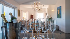 A dining area with a metal bucket containing champagne bottles and empty wine glasses on a table. - Exclusive villa with padel court [03] (Lagos)