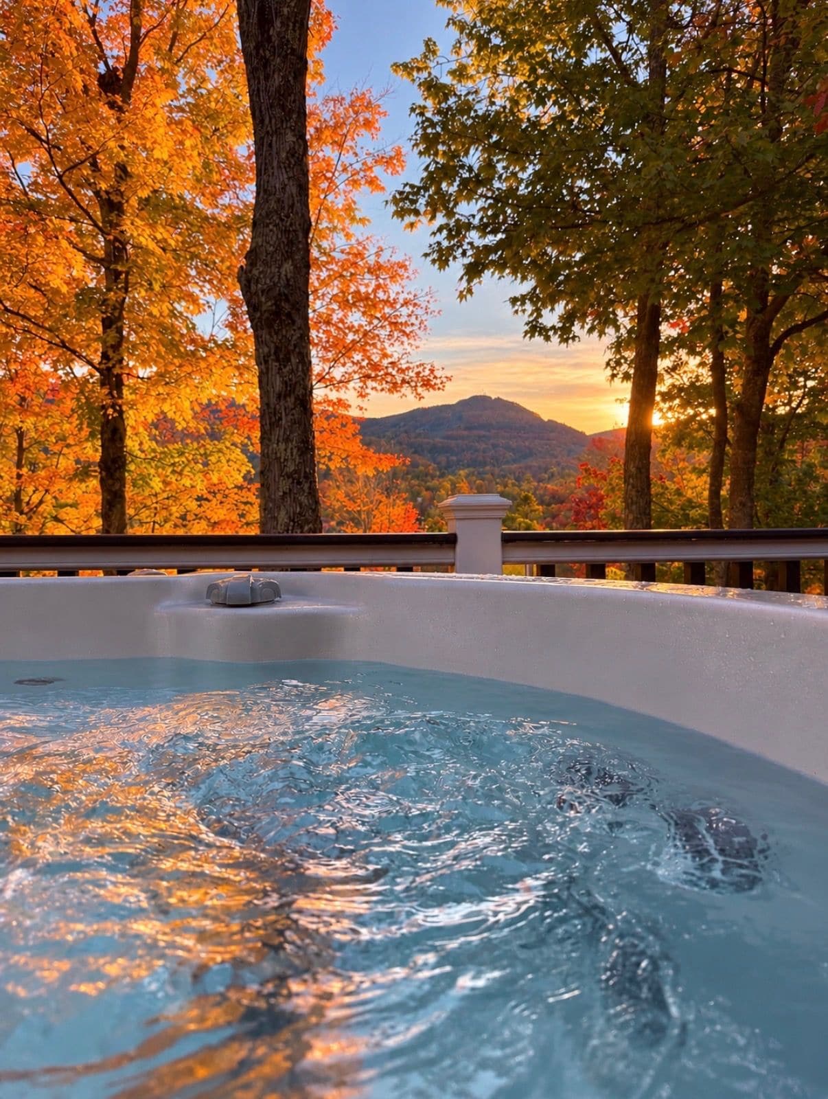 A hot tub with a view of autumn trees and a mountain in the background.