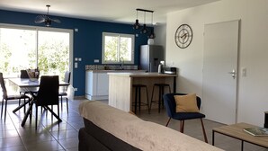 A modern kitchen with a dining area, a sofa, and a coffee table.
