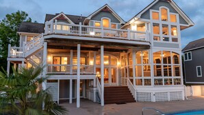 A multi-story house with a balcony and a covered porch area. - 7th Heaven: Private Pool, Spa, Game Room (Corolla)