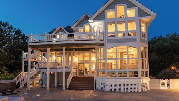 A two-story house with a balcony and a covered porch. - 7th Heaven: Private Pool, Spa, Game Room (Corolla)