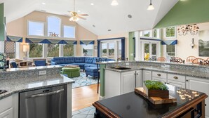 A spacious kitchen with granite countertops, a built-in oven, and a large island with a sink. - 7th Heaven: Private Pool, Spa, Game Room (Corolla)