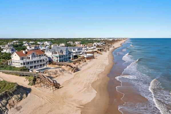 Enjoy ocean access from our beachfront homes, featuring gabled roofs and large windows.