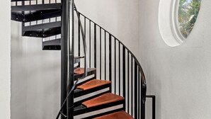 A spiral staircase with black railings and wooden steps.