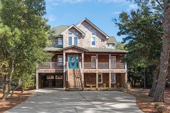 A two-story house with a balcony, a garage, and a front porch.
