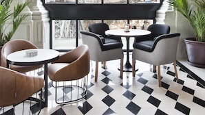 A room with a large arched window, a black and white checkered floor, and a table with chairs. - Hotel Vincci Ponte de Ferro (Vila Nova de Gaia)