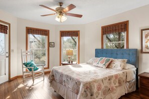 A bedroom with a bed, a chair, a nightstand, and a ceiling fan. - Sunny Days: Oceanside, Dog-friendly and short drive to the beach! (Corolla)