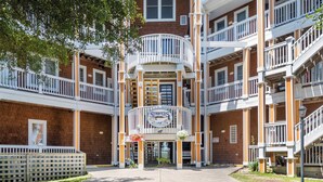 A multi-story building with a central entrance, balconies, and a sign reading "Stripers." - North Bay Retreat: Waterfront, Shared Pool, Fitness Center, Short Stays Anytime (Manteo)
