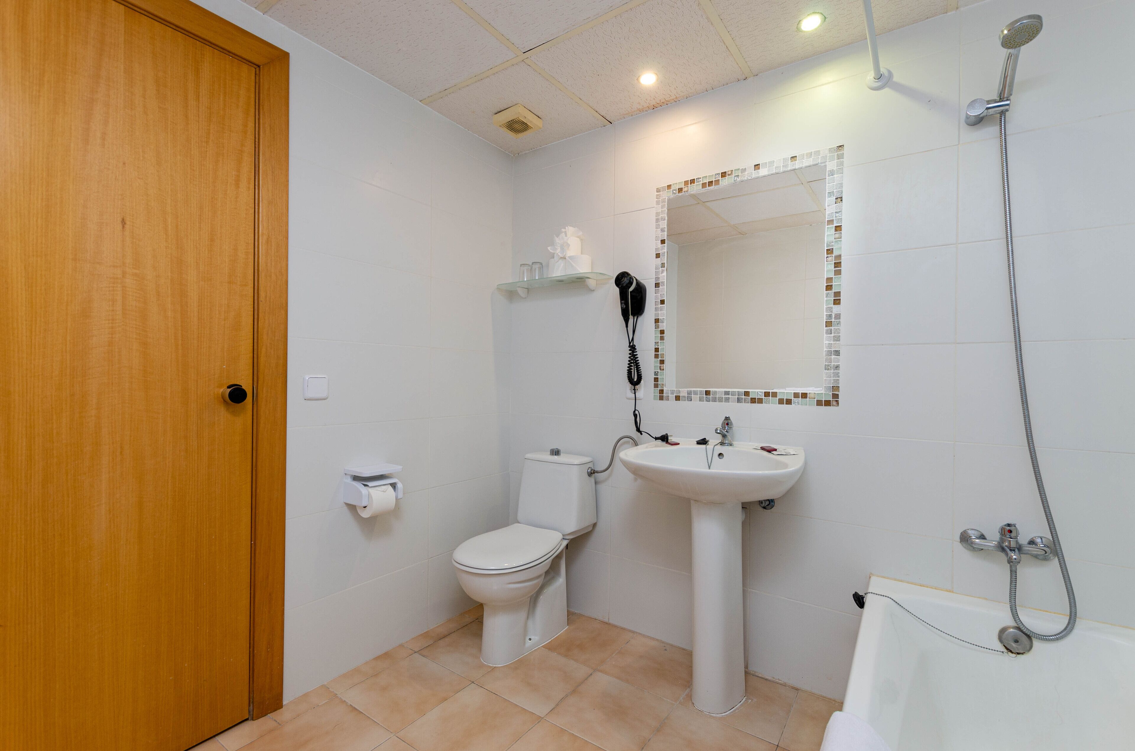 Un baño con inodoro, lavamanos y ducha.