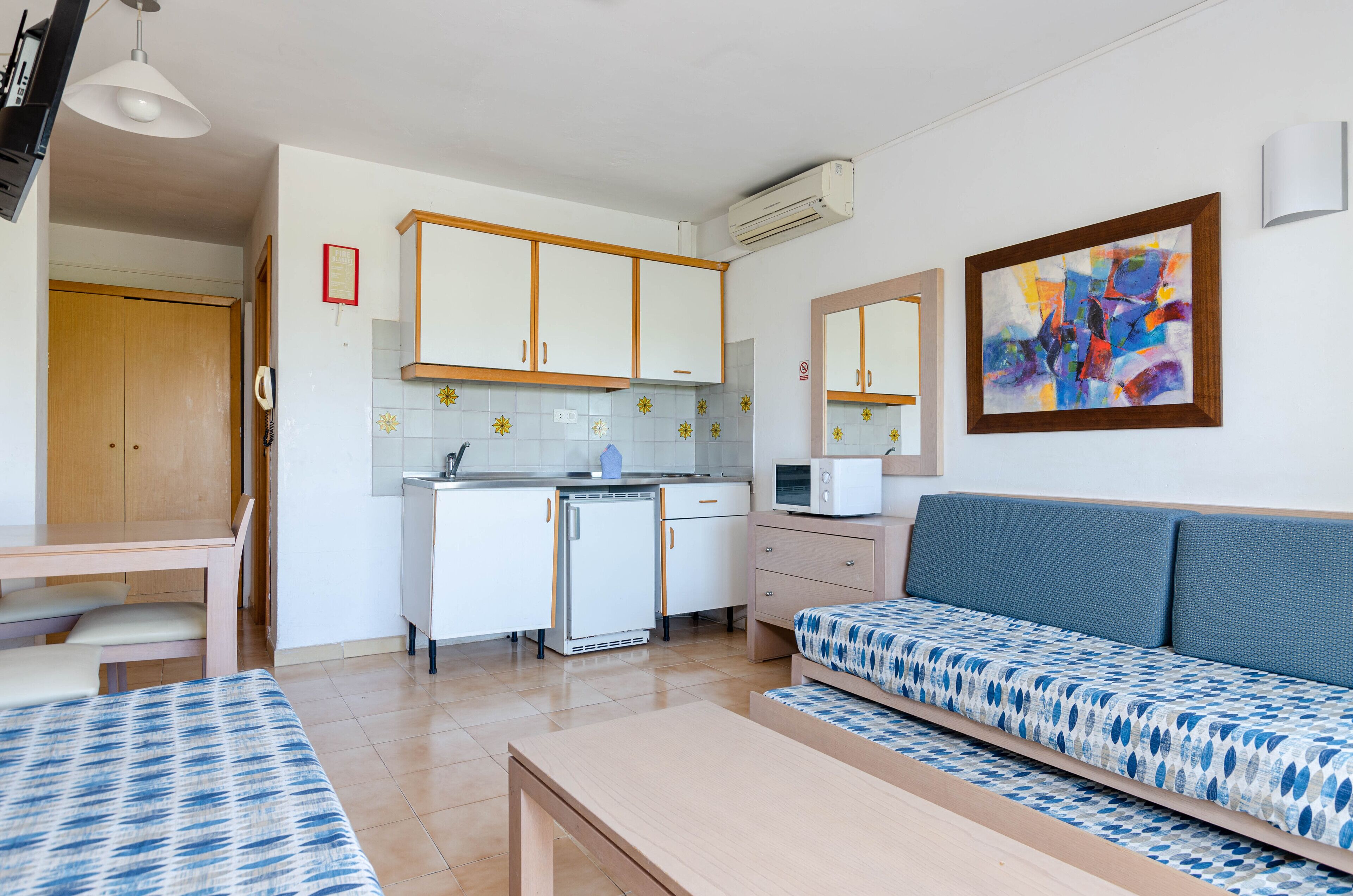 Een knus verblijf met een kitchenette, een bank, een eettafel en een bed.