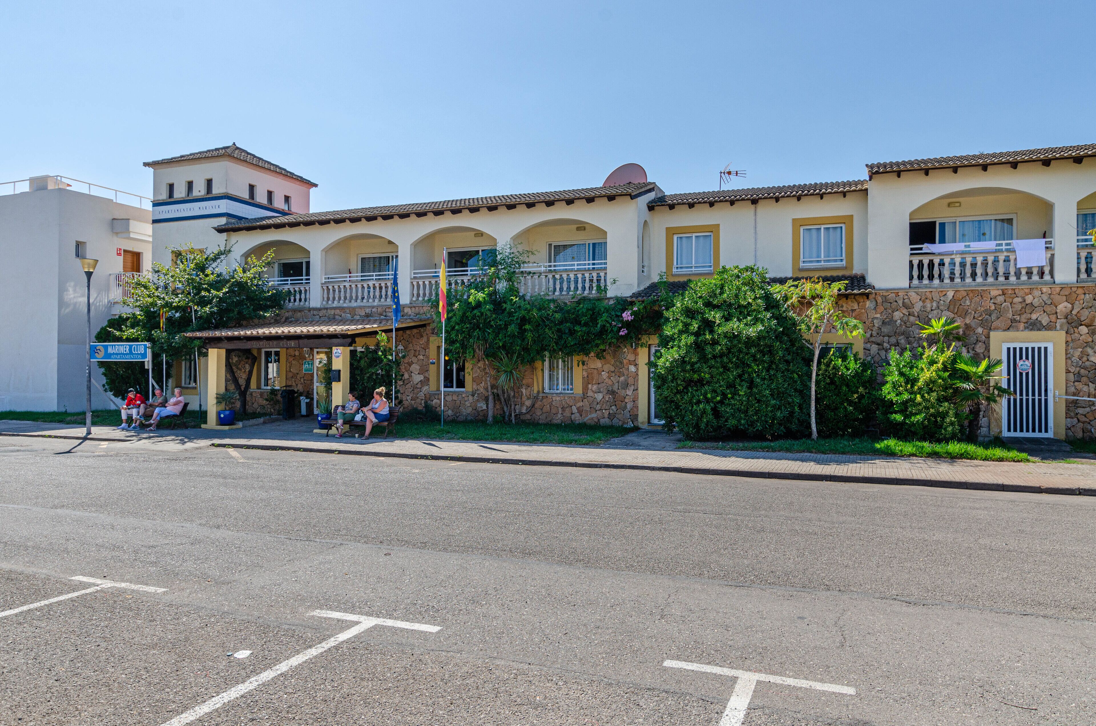 A building with a stone facade, multiple balconies, and a sign indicating a club.