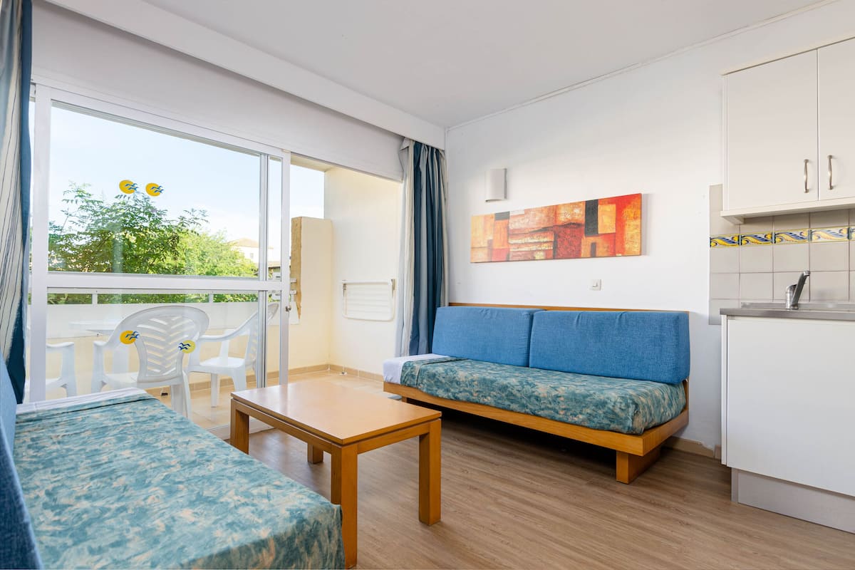 Ein modernes Wohnzimmer mit einer Couch, einem Tisch und einem Balkon mit Sitzgelegenheiten.