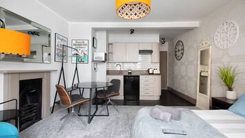 Ein modernes Hotelzimmer mit Essbereich, Küchenzeile und Kamin.