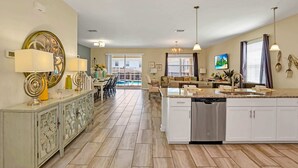 A spacious kitchen with a central island, a dining area with a view of the outdoors, and a living area with a pool view. - Stunning and Spacious Home Near Disney, CDC Standards #rcg8521 (Davenport)