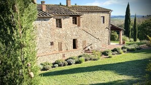 Une maison en pierre avec un toit en pente, un petit porche et une pelouse bien entretenue.
