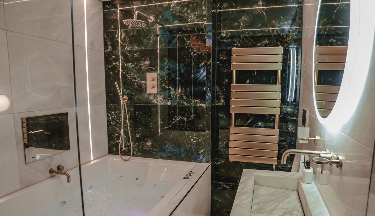 A modern bathroom with a glass-enclosed shower, a bathtub, and a vanity with a mirror.