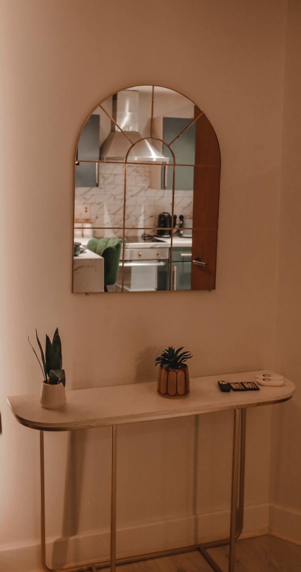 Uma cozinha com um espelho grande e arqueado sobre a bancada.