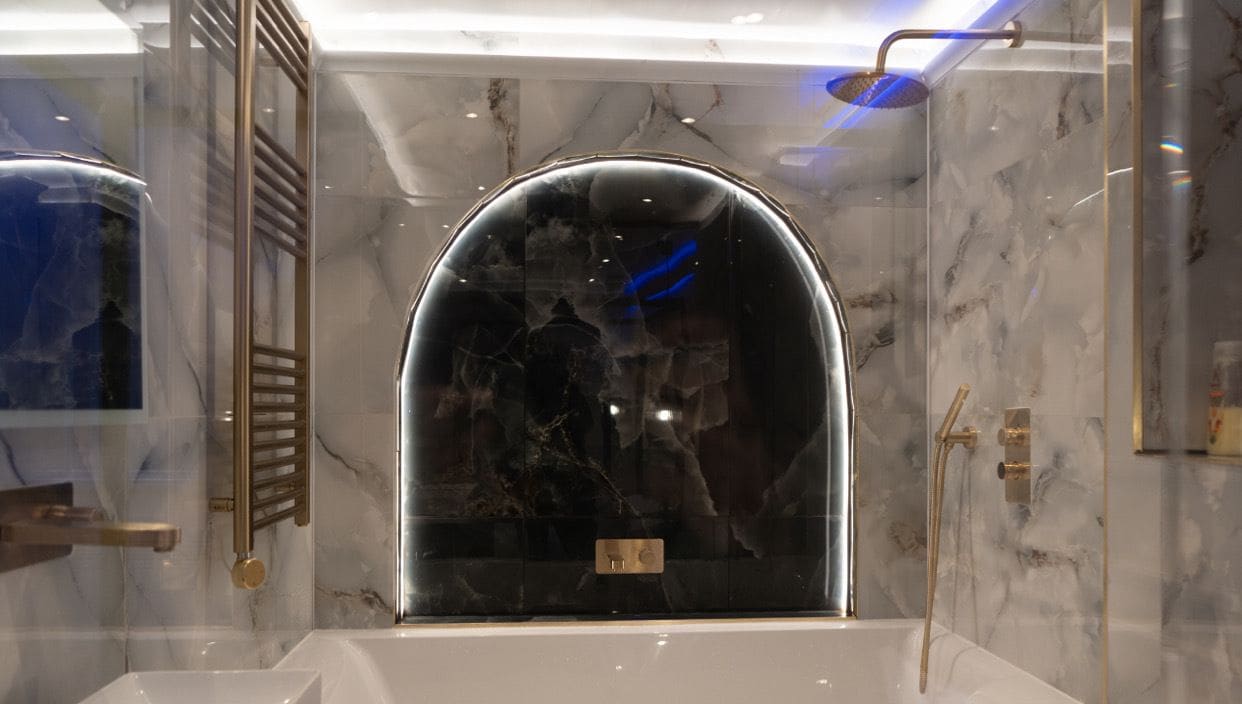 Une salle de bain moderne avec une grande baignoire, une douche à l’italienne et des murs en marbre.